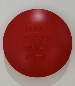 Aluminiumlinse farbig lackiert und beschriftet mit "Alles Fotzen Ausser Mutti" vom Künstler Jan M. Petersen
