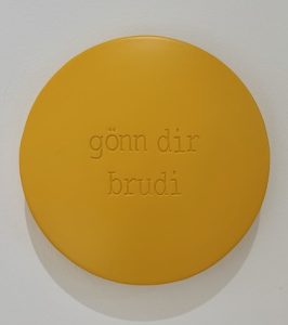 Aluminiumlinse farbig lackiert und beschriftet mit "gönn dir brudi" vom Künstler Jan M. Petersen