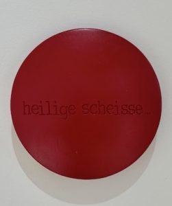 Aluminiumlinse farbig lackiert und beschriftet mit "heilige scheisse" vom Künstler Jan M. Petersen