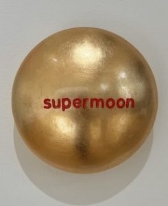 Aluminiumlinse mit Goldlack lackiert und beschriftet mit "supermoon" vom Künstler Jan M. Petersen