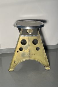 Das Projekt Aero 1946 kombiniert die Handwerksarbeit nach dem klassischen Flugzeugbau der 1940er Jahre mit dem Prinzip des Upcyclings. Das Material stammt in der Regel von Heckauslegern, Finne oder Elevatoren alter BELL-Hubschrauber. Die ultraleichten Hocker sind stylische Unikate und sehr belastbar. Die unterschiedlichen Farben, Beschriftungen und Nietlöcher verweisen auf die ursprüngliche Verwendung. Jeder Hocker ist auf der Unterseite mit dem passenden Typenschild versehen.