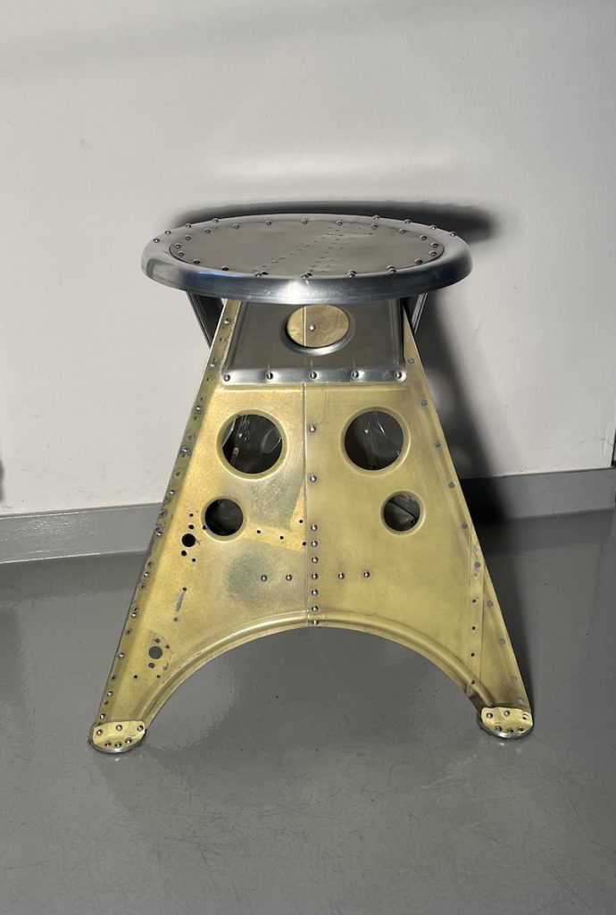 Das Projekt Aero 1946 kombiniert die Handwerksarbeit nach dem klassischen Flugzeugbau der 1940er Jahre mit dem Prinzip des Upcyclings. Das Material stammt in der Regel von Heckauslegern, Finne oder Elevatoren alter BELL-Hubschrauber. Die ultraleichten Hocker sind stylische Unikate und sehr belastbar. Die unterschiedlichen Farben, Beschriftungen und Nietlöcher verweisen auf die ursprüngliche Verwendung. Jeder Hocker ist auf der Unterseite mit dem passenden Typenschild versehen.