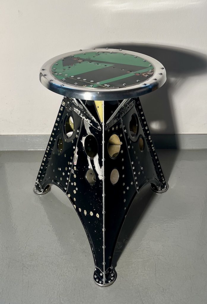 Das Projekt Aero 1946 kombiniert die Handwerksarbeit nach dem klassischen Flugzeugbau der 1940er Jahre mit dem Prinzip des Upcyclings. Das Material stammt in der Regel von Heckauslegern, Finne oder Elevatoren alter BELL-Hubschrauber. Die ultraleichten Hocker sind stylische Unikate und sehr belastbar. Die unterschiedlichen Farben, Beschriftungen und Nietlöcher verweisen auf die ursprüngliche Verwendung. Jeder Hocker ist auf der Unterseite mit dem passenden Typenschild versehen.