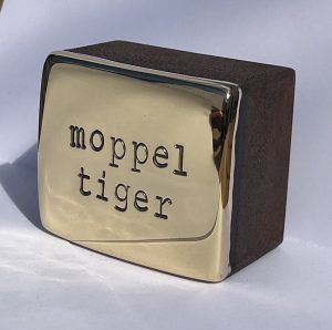 Den Künstler Jan M. Petersen arbeitet hier mit Cortenstahl und Bronze vergoldet. Geprägte Schrift: moppeltieger