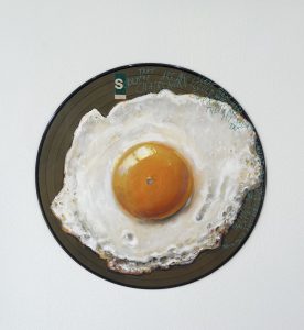 Liebe Kunstfreunde, erstmalig hat der Künstler Frank Damm auf alten Vinyl und Schellack Schallplatten gemalt. Es entstanden sensationelle Kunstwerke mit einer beeindruckenden Tiefe. Das Pizzastück das auf der Schellack-Platte liegt oder der Espresso der darauf steht. Jedes Stück ein tolles Unikat. Handsigniert und rückseitig betitelt & gestempelt. Geliefert werden die Arbeiten jeweils in einer schwarzen Hülle und einem Zertifikat auf Büttenpapier. Auf Wunsch können wir die Unikate auch für Sie einrahmen lassen. Titel: Gold Schallplatte Gold gefärbt mit Spiegel Ei Motiv