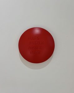 Aluminiumlinse farbig lackiert und beschriftet mit "Alles Fotzen Ausser Mutti" vom Künstler Jan M. Petersen