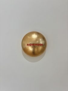 Aluminiumlinse mit Goldlack lackiert und beschriftet mit "supermoon" vom Künstler Jan M. Petersen