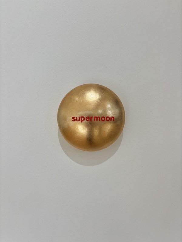 Aluminiumlinse mit Goldlack lackiert und beschriftet mit "supermoon" vom Künstler Jan M. Petersen