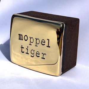 Den Künstler Jan M. Petersen arbeitet hier mit Cortenstahl und Bronze vergoldet. Geprägte Schrift: moppeltieger